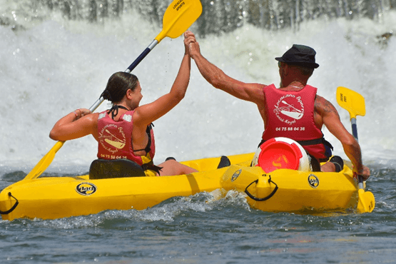 Two people celebrating with a high five during their canoe adventure on the Ardèche river
