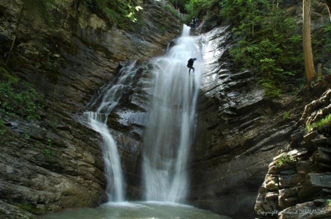 Person abseiling down a waterfall in the spectacular gorges of Ardèche during a canyoning adventure