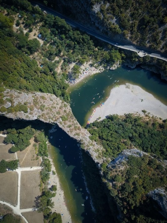 Stunning aerial view of the Ardèche river winding through the limestone canyon, showcasing millions of years of geological formation